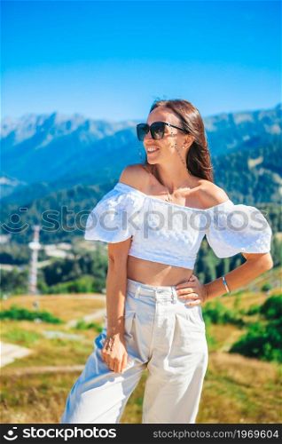Beautiful happy young woman in mountains on vacation. Beautful landscape. Beautiful happy young woman in mountains in the background of fog