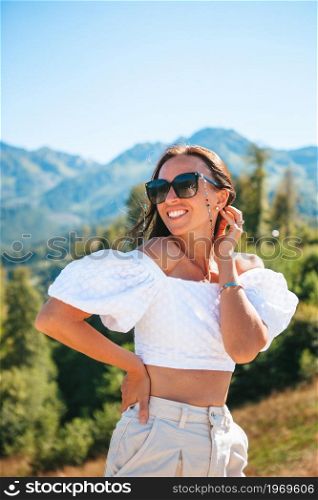 Beautiful happy young woman in mountains on vacation. Beautful landscape. Beautiful happy young woman in mountains in the background of fog