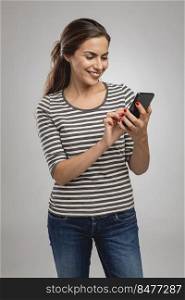 Beautiful happy young woman sendind a text message to someone