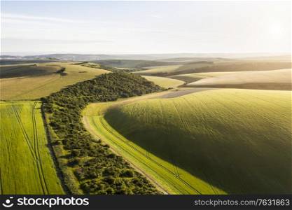 Beautiful high flying drone landscape image of rolling hills in English countryside with lovely warm light