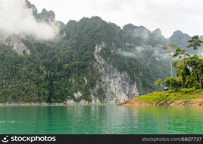 Beautiful high mountains and green lake in morning at Ratchaprapha Dam, Khao Sok National Park, Surat Thani Province, Thailand