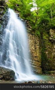 Beautiful high waterfall in the green forest