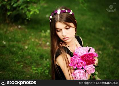 Beautiful hippy bohemian fashion style model in beautiful lake environment. Brunette woman with flowers enjoying nature against nature background