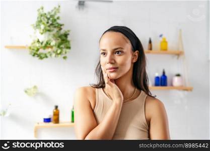 Beautiful hispanic brunette portrait against white tiled wall with cosmetics. Wellness and natural cosmetics. Beautiful hispanic brunette on cosmetic background