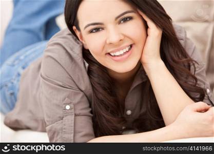 Beautiful Hispanic Woman Laying on Sofa Relaxing & Smiling