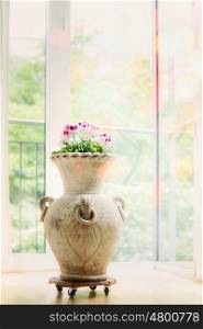 Beautiful home interior decoration with amphora vase and flowers at window