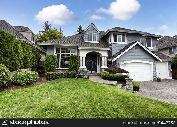 Beautiful home with green grass yard and blooming hydrangea flowers in summer season  