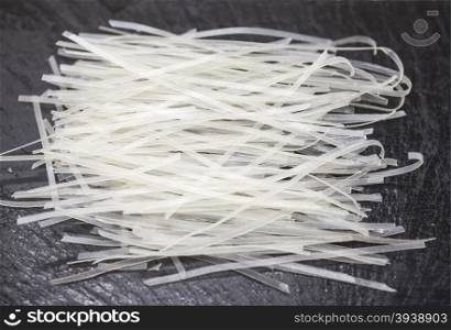 Beautiful homemade Japanese rice noodles from durum wheat on stone background, closeup.