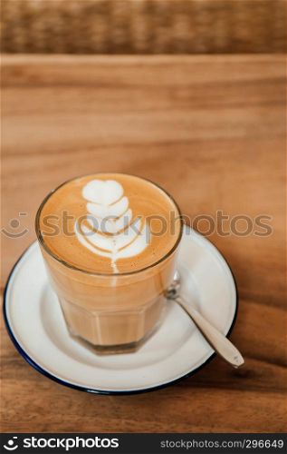 Beautiful hot Coffee Latte with nice crema form on top on wood table , close up shot