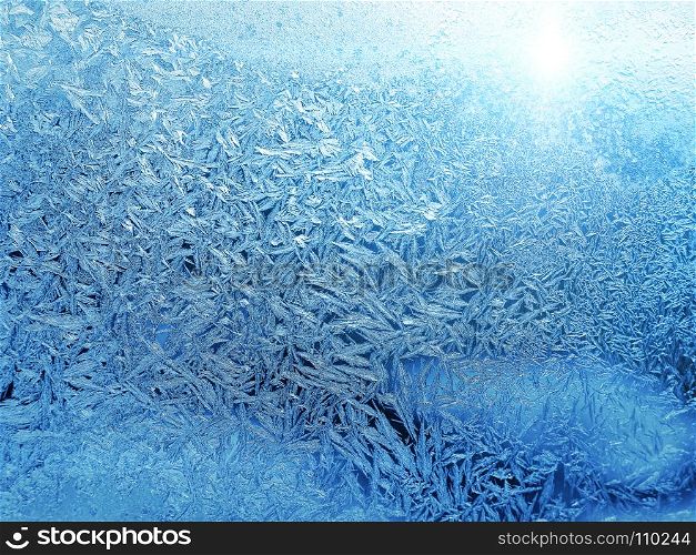 Beautiful ice pattern and sunlight close-up on winter window glass