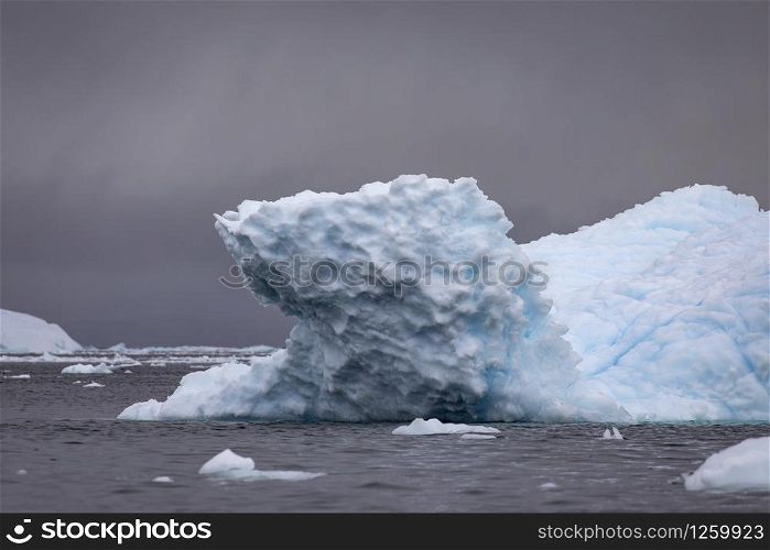Beautiful iceberg up close with detail of blue shimmering ice on surface with mood lighting