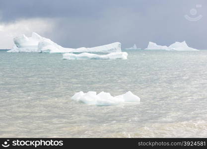 Beautiful icebergs. Beautiful icebergs in the sun and in front of a dark sky