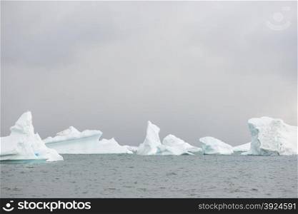 Beautiful icebergs. Beautiful icebergs in the sun and in front of a dark sky