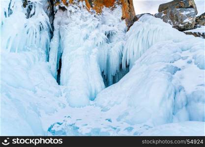 Beautiful icicles and snow at rocky island in Frozen Lake Baikal, Russia
