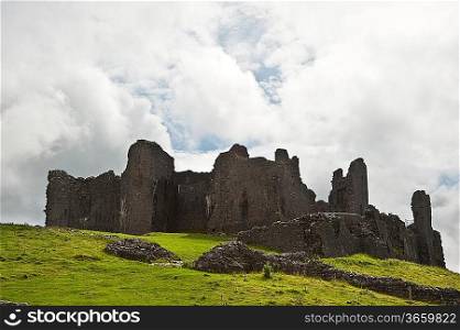 Beautiful image of medieval castle ruins in landscape with moody sky background