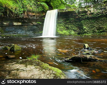 Beautiful image of waterfall in forest with stram and lush green foliage