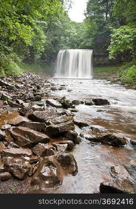 Beautiful image of waterfall in forest with stram and lush green foliage