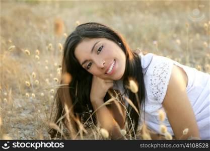 Beautiful indian brunette having a rest on a golden summer field