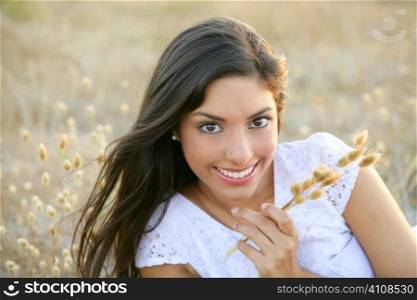 Beautiful indian brunette having a rest on a golden summer field