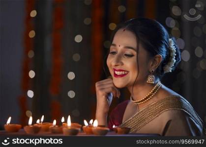 Beautiful Indian woman enjoying and smiling at home on the occasion of Diwali