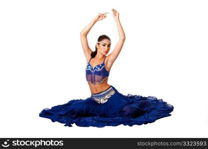 Beautiful Israeli Egyptian Lebanese Middle Eastern belly dancer performer in blue skirt and bra with arms in air sitting, isolated.