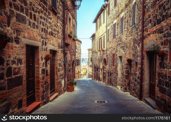 Beautiful Italian street of old town in Italy. Houses are neatly decorated with colorful plant and flowers.. Beautiful Italian street of old town in Italy.