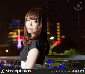 Beautiful Japanese female with bright lights of city in background