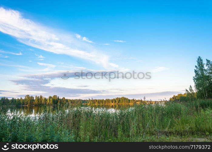 Beautiful Karelian landscape in the orange rays of the setting sun, Russia.