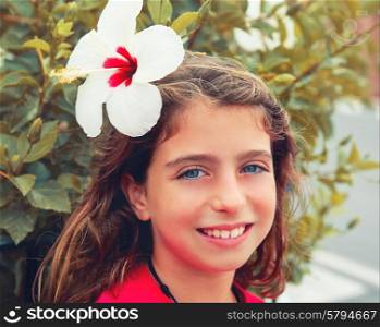 Beautiful kid girl with hibiscus flower in hair blue eyes