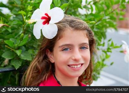 Beautiful kid girl with hibiscus flower in hair blue eyes