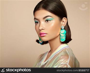 Beautiful Korean Woman with Large Turquoise Earrings. Perfect Makeup and Elegant Hairstyle. Turquoise Make-up Arrows and Pink Lipstick