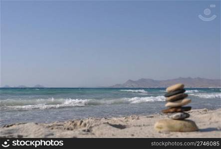 beautiful Kos beach with defocused pebble stack, Greece (Turkey on background)