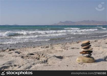 beautiful Kos beach with defocused pebble stack, Greece (Turkey on background)