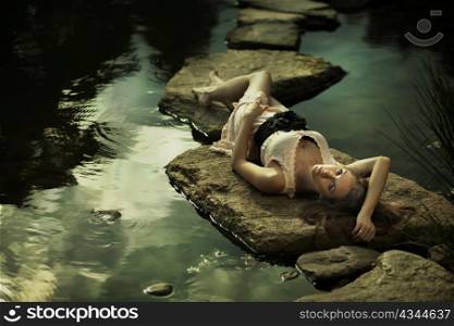 Beautiful lady lying on rocks