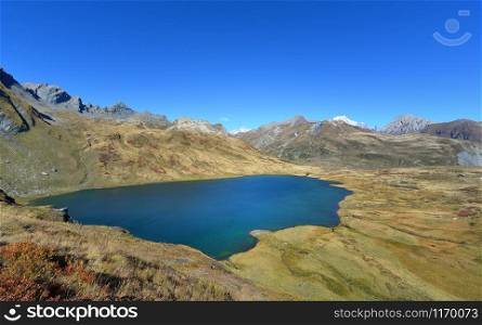 beautiful lake in alpine mountain in autumn under blue sky