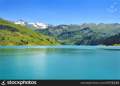 beautiful lake in alpine valley with snowy mountain in far off