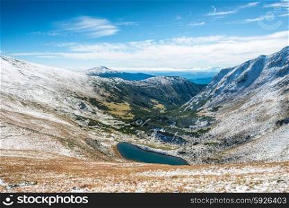 Beautiful lake in the winter mountains. Landscape with sun and snow