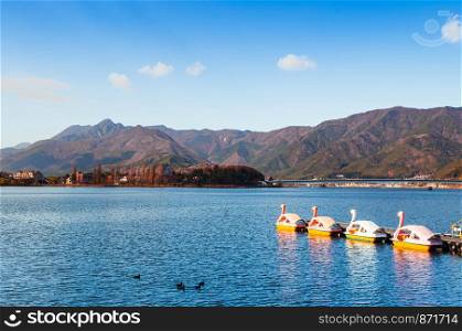 Beautiful Lake Kawaguchiko in winter with swan water bike boats and mountains view. Yamanashi - Japan