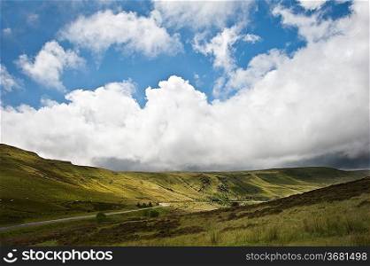 Beautiful landscape across countryside to mountains in distance with moody sky