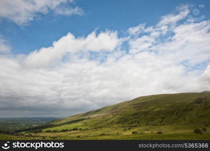 Beautiful landscape across countryside to mountains in distance with moody sky