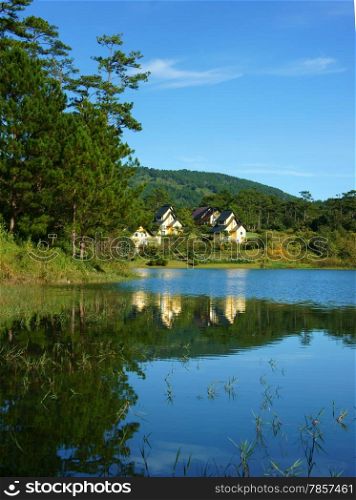 Beautiful landscape at Dalat village, group of villas reflect on lake, eco holiday resort among green pine forest, fresh air, pure environment, romantic scene for honeymoon at Da Lat, Vietnam