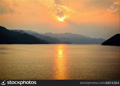 Beautiful landscape during sunset over a mountain ranges at lake in Srinakarin Dam, Kanchanaburi Province, Thailand