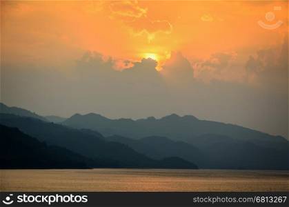 Beautiful landscape during sunset over a mountain ranges at lake in Srinakarin Dam, Kanchanaburi Province, Thailand
