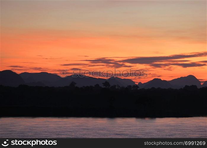 beautiful landscape, early morning on the river with silhouette mountains and tree