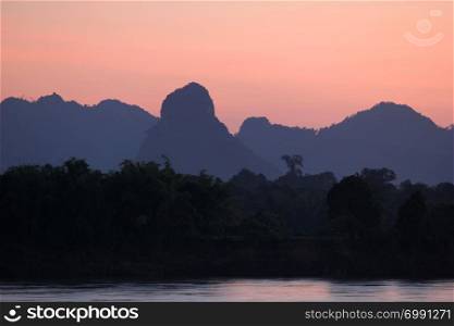 beautiful landscape, early morning on the river with silhouette mountains and tree