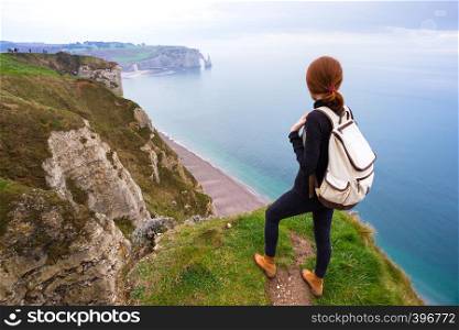 beautiful landscape, girl standing at the edge of rock in the Etretat. France