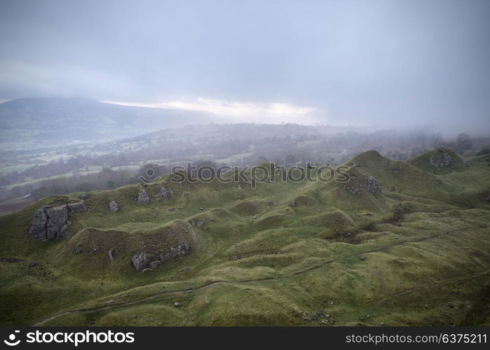 Beautiful landscape image of abandoned quarry taken over by nature in Autumn Fall at sunrise with foggy weather