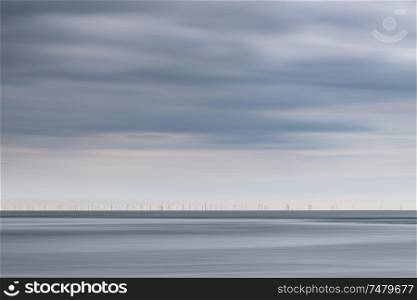 Beautiful landscape image of beach at low tide with moody storm clouds gathering overhead