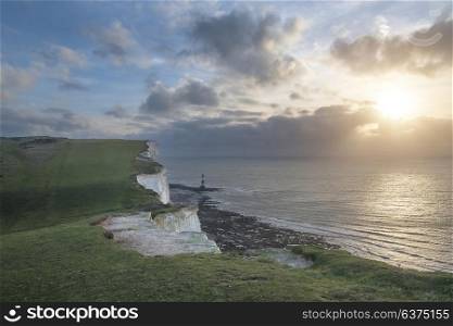 Beautiful landscape image of Beachy Headt lighthouse on South Downs National Park during stormy sky