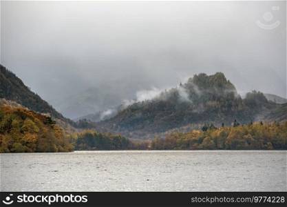Beautiful landscape image of Caste Crag shrouded in mist during Autumn view along Derwentwater in Lake District